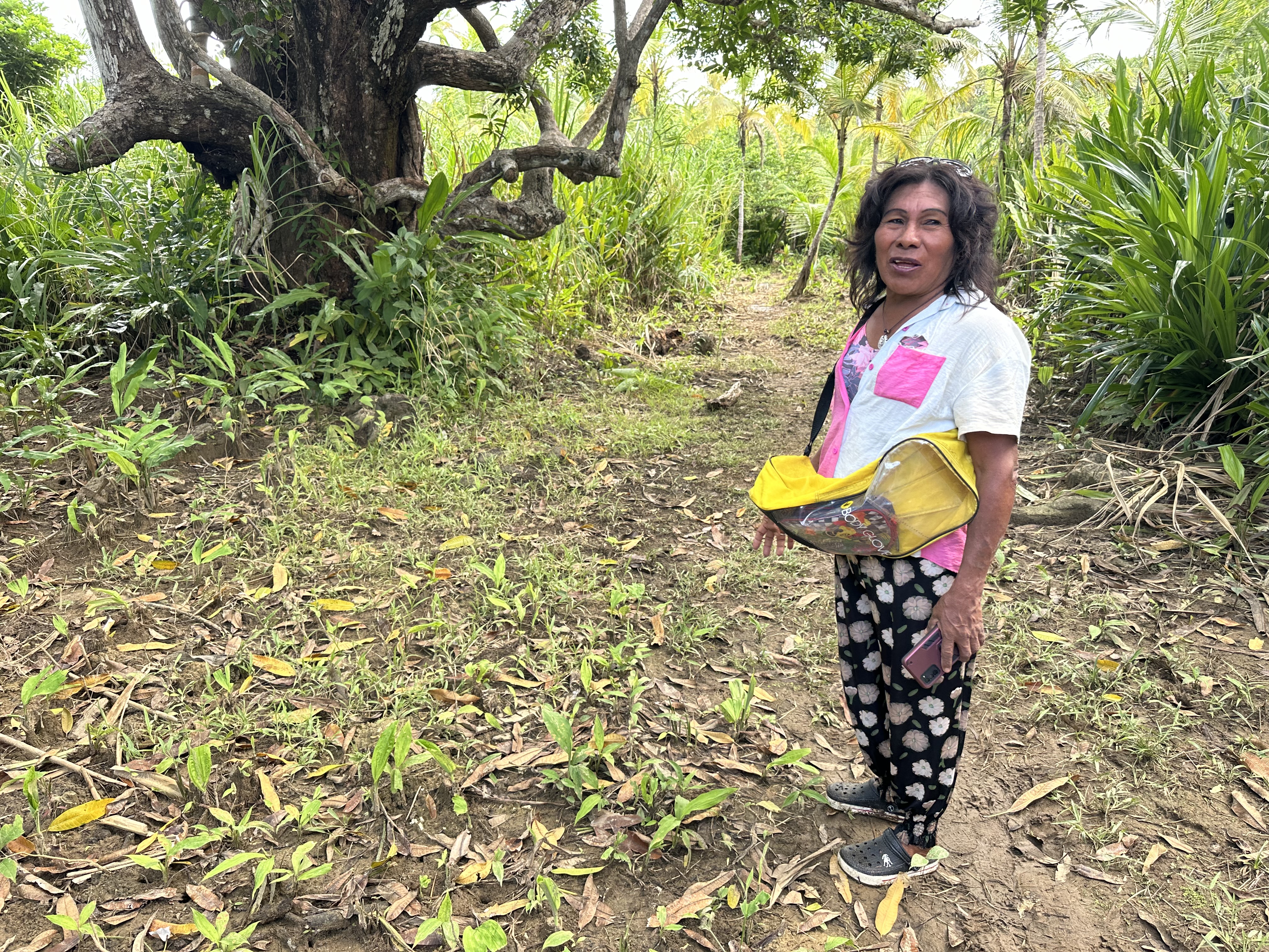 Mola Lisa im Wald von San Blas. Sie trägt Crocs und hält ihr Smartphone in der Hand.
